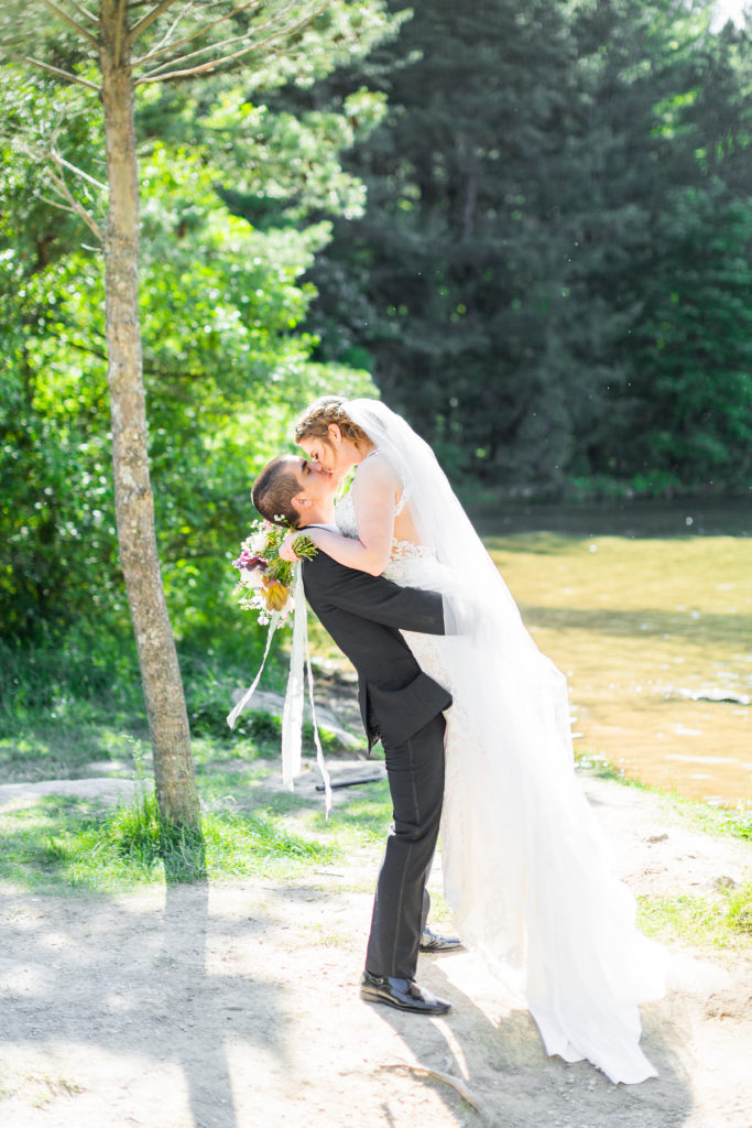 romantic woods picture of bride and groom kissing near the lake in caledonia, elopement