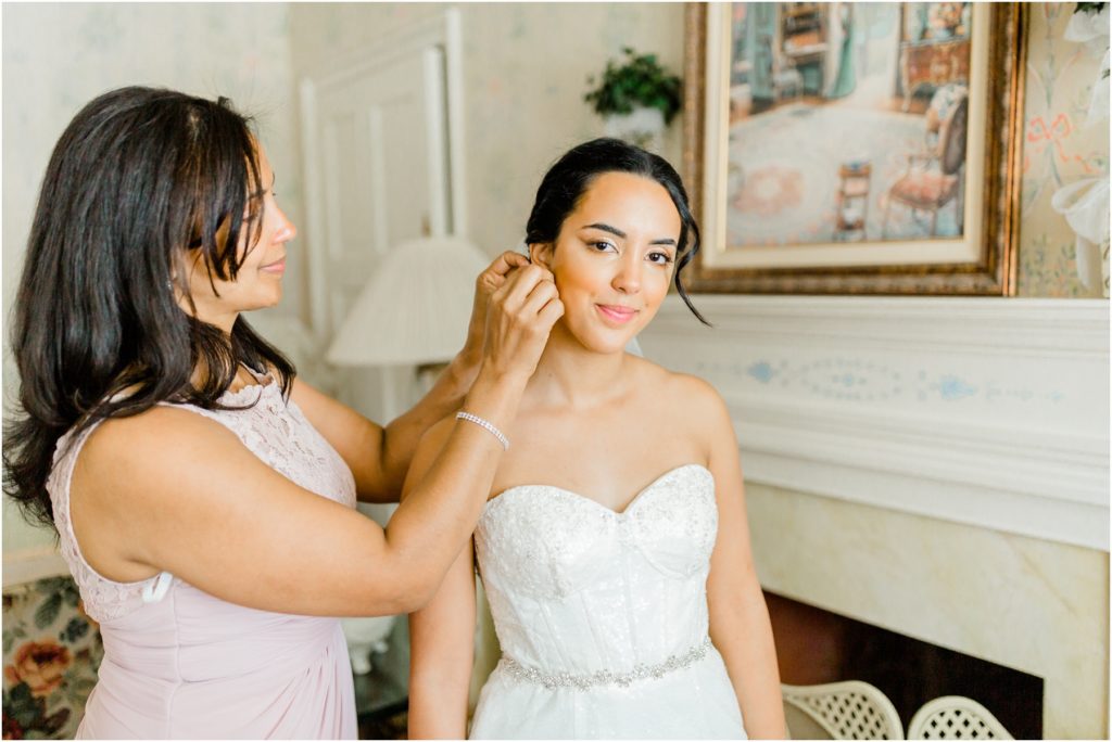 mother putting on her daughter's wedding earrings